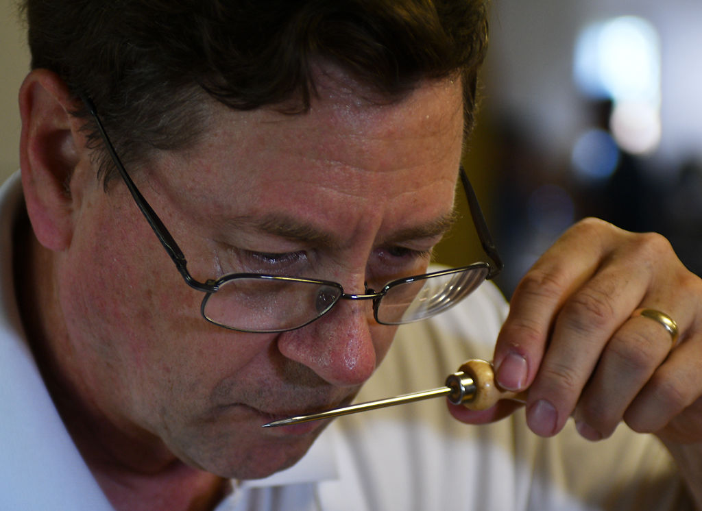 Ham judge Andrew Clarke uses a meat puncture tool to test the aroma of each ham
